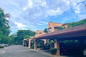 A hotel with a covered entrance, palm trees, and a clear sky.