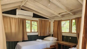 A room with two single beds, a wooden bench, and an air conditioning unit. - Kelebekler Vadisi Butterfly Valley (Fethiye)