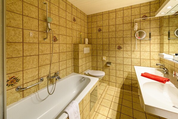 A bathroom with a bathtub, toilet, and sink.