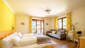 A bedroom with a bed, a sofa, a desk, and a chair. - Montfort (Lech am Arlberg)