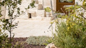 A stone building with a wooden door and potted plants. - Trullo manivida Mulberry (Locorotondo)