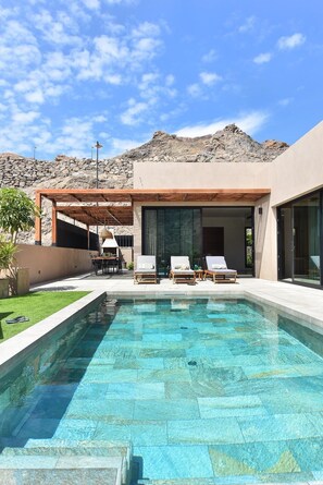 A modern pool area with a clear view of the mountains in the background.