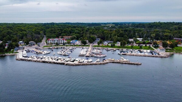 A marina with numerous boats docked, surrounded by residential buildings and greenery.