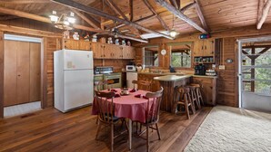 A wooden cabin with a kitchen, dining area, and a large window. - 22 miles to Round Top, 3/2 w/ trailer parking, relaxing cozy cabin w/ lake, wifi (La Grange)