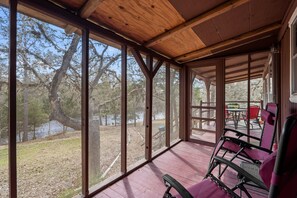 Relax on the covered porch with a view of the surrounding landscape and natural water feature.