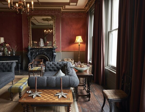 Une chambre de style traditionnel, dotée d’une cheminée, d’un grand miroir et de meubles classiques.