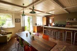 Une cuisine spacieuse avec une table en bois, des tabourets de bar et un grand îlot central.