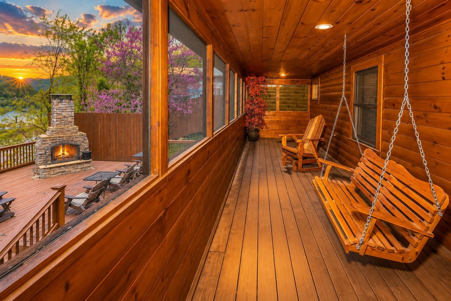 A wooden deck with a stone fireplace, outdoor seating, and a view of the landscape.