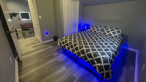 Un dormitorio con una cama, una puerta y un pasillo que da a otra habitación.