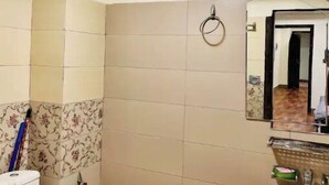 A bathroom with a toilet, sink, and a mirror. - Comfy apartment in Bahria town civic center. (Rawalpindi)