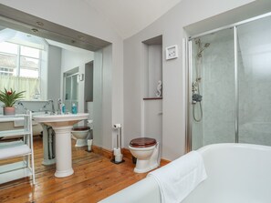 Un baño moderno con una bañera independiente, un lavabo, un inodoro y una ducha.