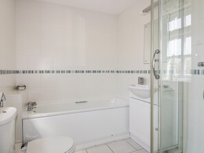 A modern bathroom with a bathtub, a toilet, and a glass-enclosed shower area. - Owls Roost (St Austell)