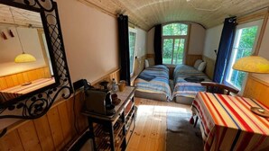 A cozy room with two beds, a wooden ceiling, a window, and a mirror. - Construction trailer - in the middle of nature (Kleve)