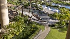 A resort with palm trees, a pool area, and a view of the landscape.
