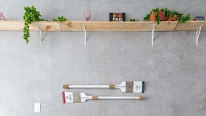 A dining area with a wooden table, black chairs, a patterned rug, and a wall-mounted utensil holder. - 6 Minutes From Ipanema Beach and Close to the Underground J804 (Rio de Janeiro)