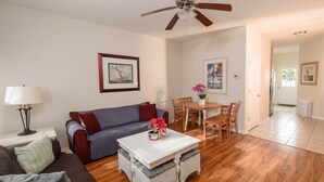 A living room with a sofa, a coffee table, and a dining area with chairs and a table. - 2-Bedroom Cottage, One Block to Beach! Free WIFI, Free Parking (Myrtle Beach)