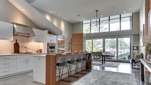 Una cucina moderna con isola centrale, sgabelli da bar e zona pranzo con vista.