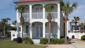 A two-story white building with a red roof, multiple balconies, and palm trees. - 9 Bedrooms / 6.5 Baths / Sleeps 28 / 8 Parking Spots / Pool / Steps to Beach!!! (Destin)