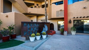 Un edifici de diversos pisos amb un rètol que diu "MARINA CABO PLAZA".