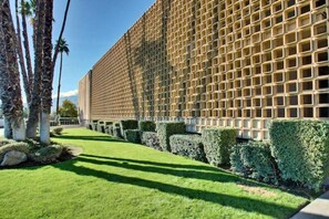 Contemporary building with a grid-like facade, set amidst well-manicured grounds.