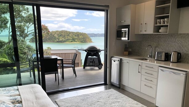 A modern kitchen with a view of a lake and forest. - Bayview Corner Suite (Unit 2) - Paihia Unit (Paihia)