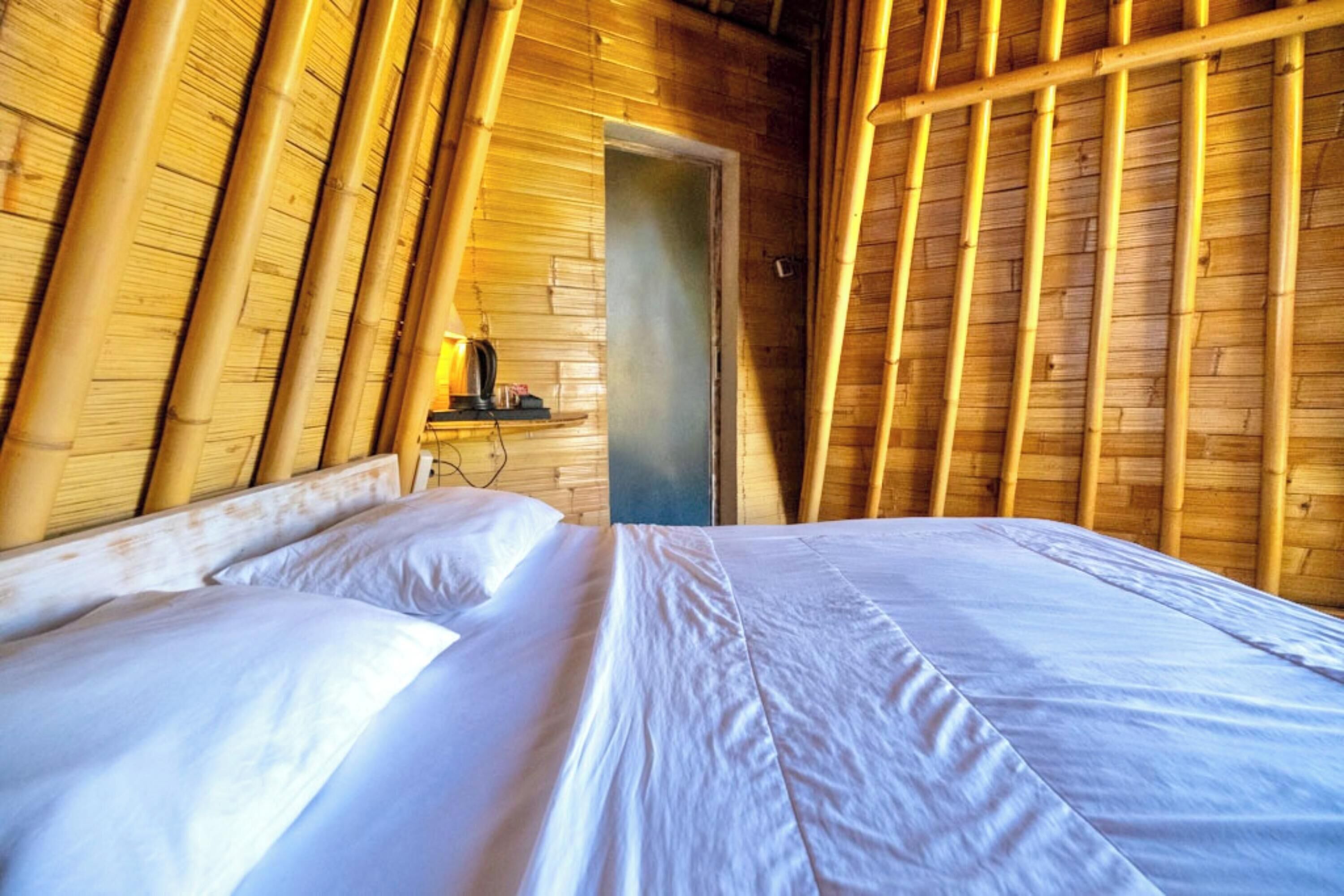 Une pièce avec un lit, des murs en bois et une porte.