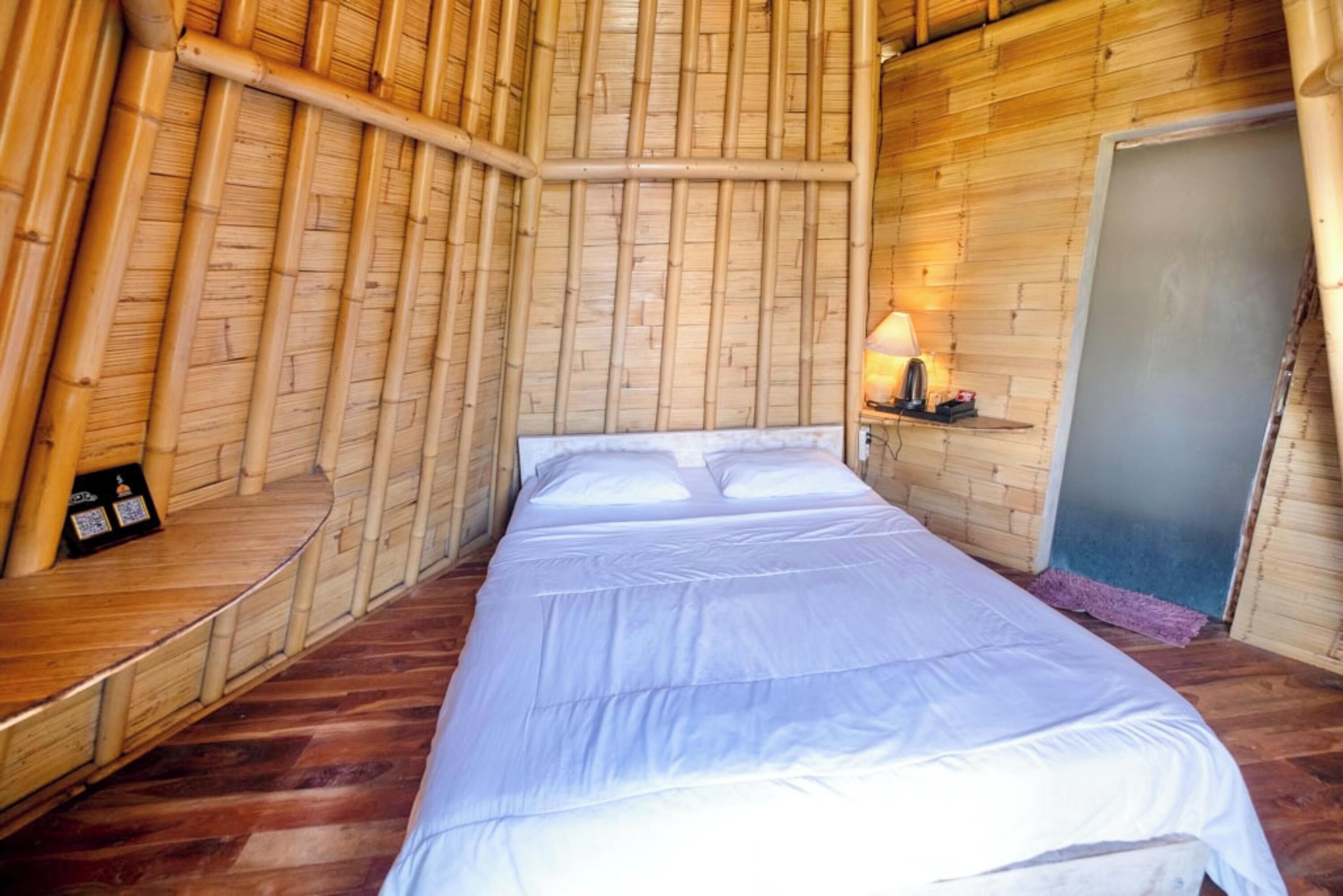 A room with a bed, a lamp, and a door.