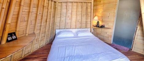 Una habitación con cama, lámpara y puerta.