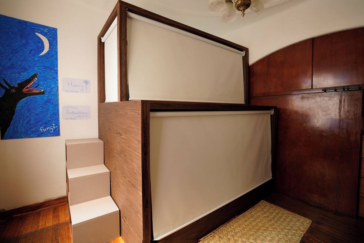 A room with a wooden staircase, a whiteboard, and a wooden cabinet.