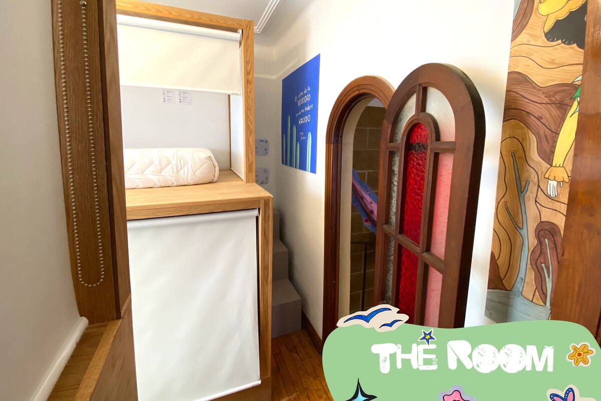A room with a bunk bed, a wooden door, and a wall with a poster.