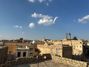 Un paysage urbain historique, avec d’anciens bâtiments en pierre et un ciel d’un bleu éclatant.