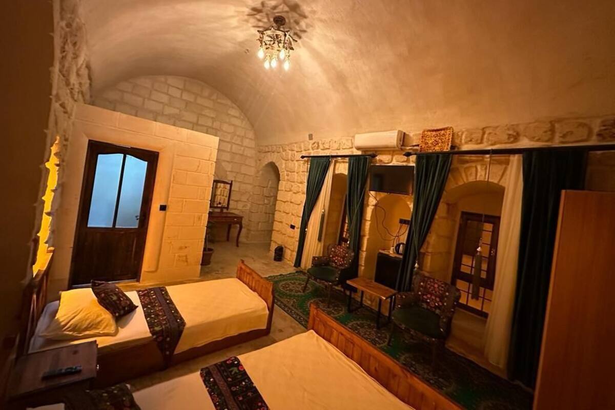 A cozy room with two beds, a small table, and a mirror.