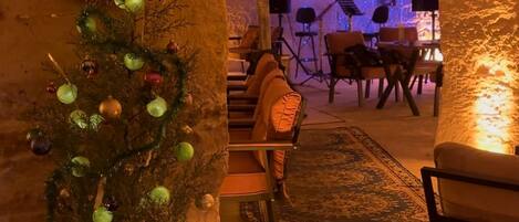 An indoor space with a Christmas tree, a '2021' decoration, and a cozy seating area with chairs and a table.