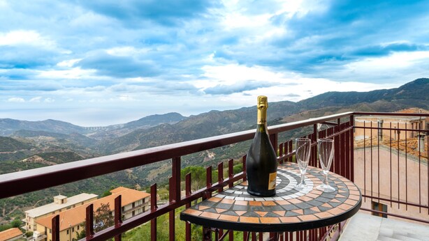 A balcony with a wine bottle and glasses, overlooking a mountainous landscape. - Angel's Holiday Apartment - Panoramic Relax (San Mauro Castelverde)