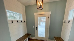 A hallway with a bench, a door, and a window.