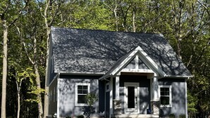 A two-story house with a gabled roof, a front porch, and a number '512' on the side.