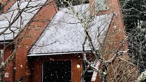 A snow-covered building with a brick exterior, a visible window, and a door marked "HAPPY". - Charming Loft Cabin - Best Location Davis, Thomas, Canaan Valley. Cold AC (Davis)