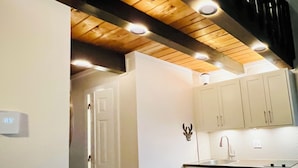 A kitchen with white cabinets, a wooden ceiling, and a modern faucet. - Charming Loft Cabin - Best Location Davis, Thomas, Canaan Valley. Cold AC (Davis)