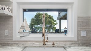 A bathroom with a large window, a bathtub, and a towel rack. - Spectacular ocean getaway, vacation done right! (Beaufort)