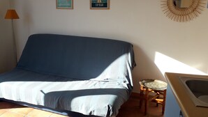 A room with a bed, a small wooden table, a floor lamp, and two wall-mounted pictures. - 5mn from the sea studio T1 Banyuls sur mer (Banyuls-sur-Mer)