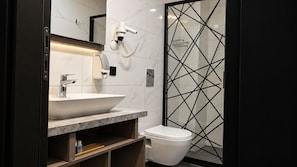 A modern bathroom with a white sink, a mirror, a hairdryer, and a toilet. - Talles City Hotel (Izmir)