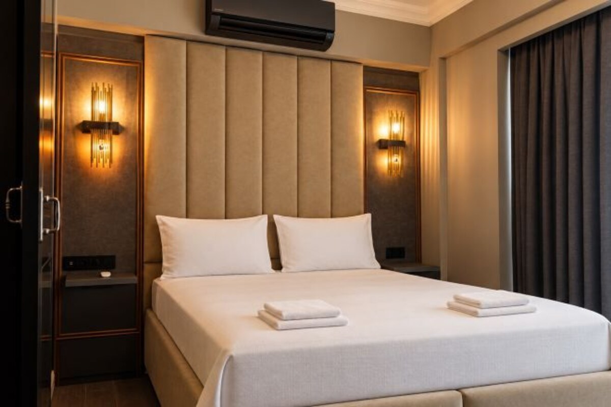Ein Hotelzimmer mit einem großen Bett, zwei Nachttischen und Wandleuchten.