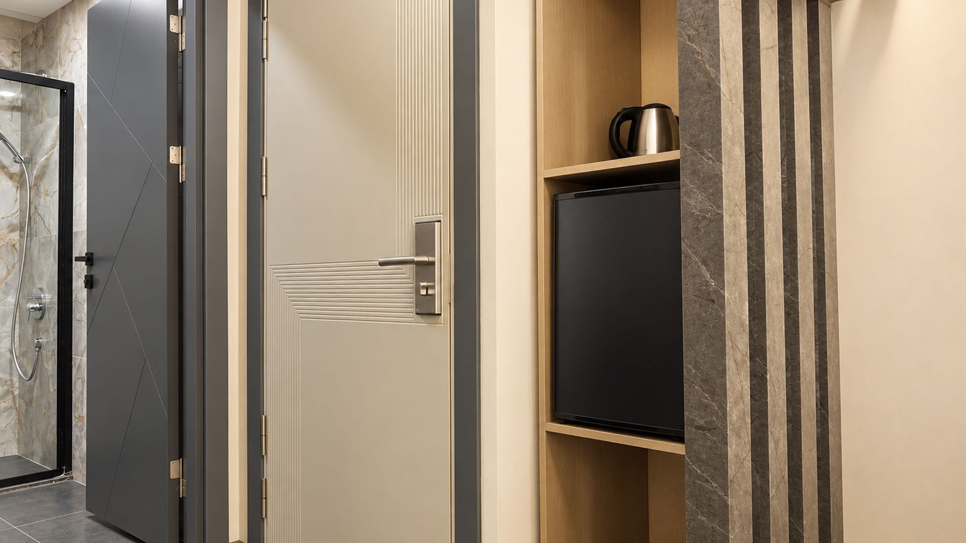 Habitación de hotel con puerta, armario empotrado y zona de ducha.