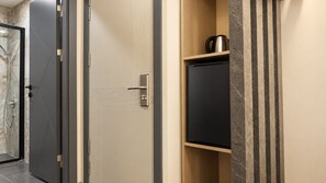 A hotel room with a door, a built-in cabinet, and a shower area. - Talles City Hotel (Izmir)