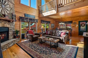 A spacious living room with a fireplace, a dining area, and a kitchen.
