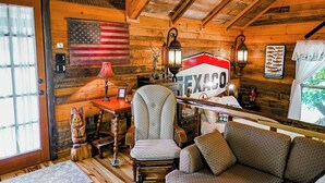 A rustic cabin interior with a wooden interior, a Texaco sign, a flag, and a cozy seating area. - Fabulous Shack in the heart of Tellico Plains... (Tellico Plains)
