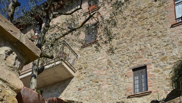 A stone staircase leading up to a building with a small window and a balcony. - La Petronilla Montepetriolo - Apartment Delight (Monte Petriolo)