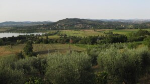 A rural landscape with a lake, rolling hills, and scattered houses. - La Petronilla Montepetriolo - Apartment Delight (Monte Petriolo)