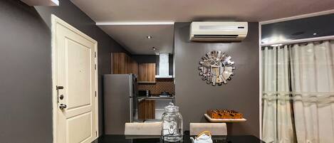 Een moderne keuken met een eethoek, met een glazen pot, een witte theepot en een decoratieve spiegel aan de muur.
