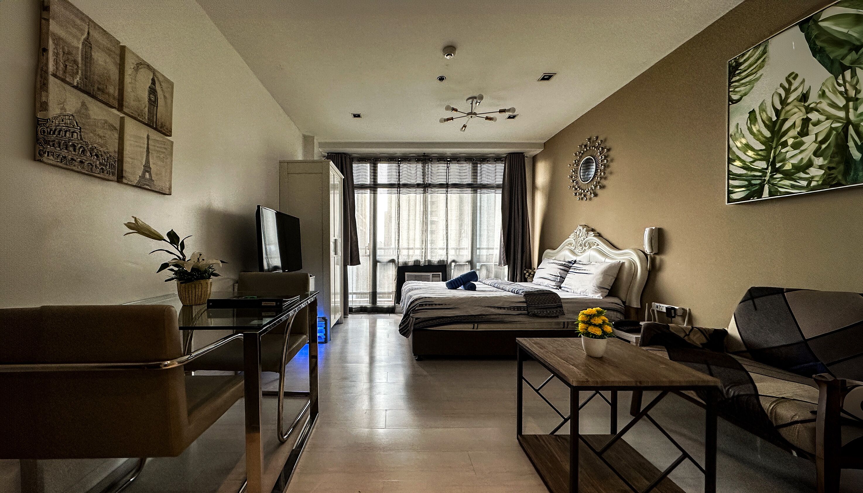 A modern living room with a sofa, a coffee table, a TV, and a dining table.